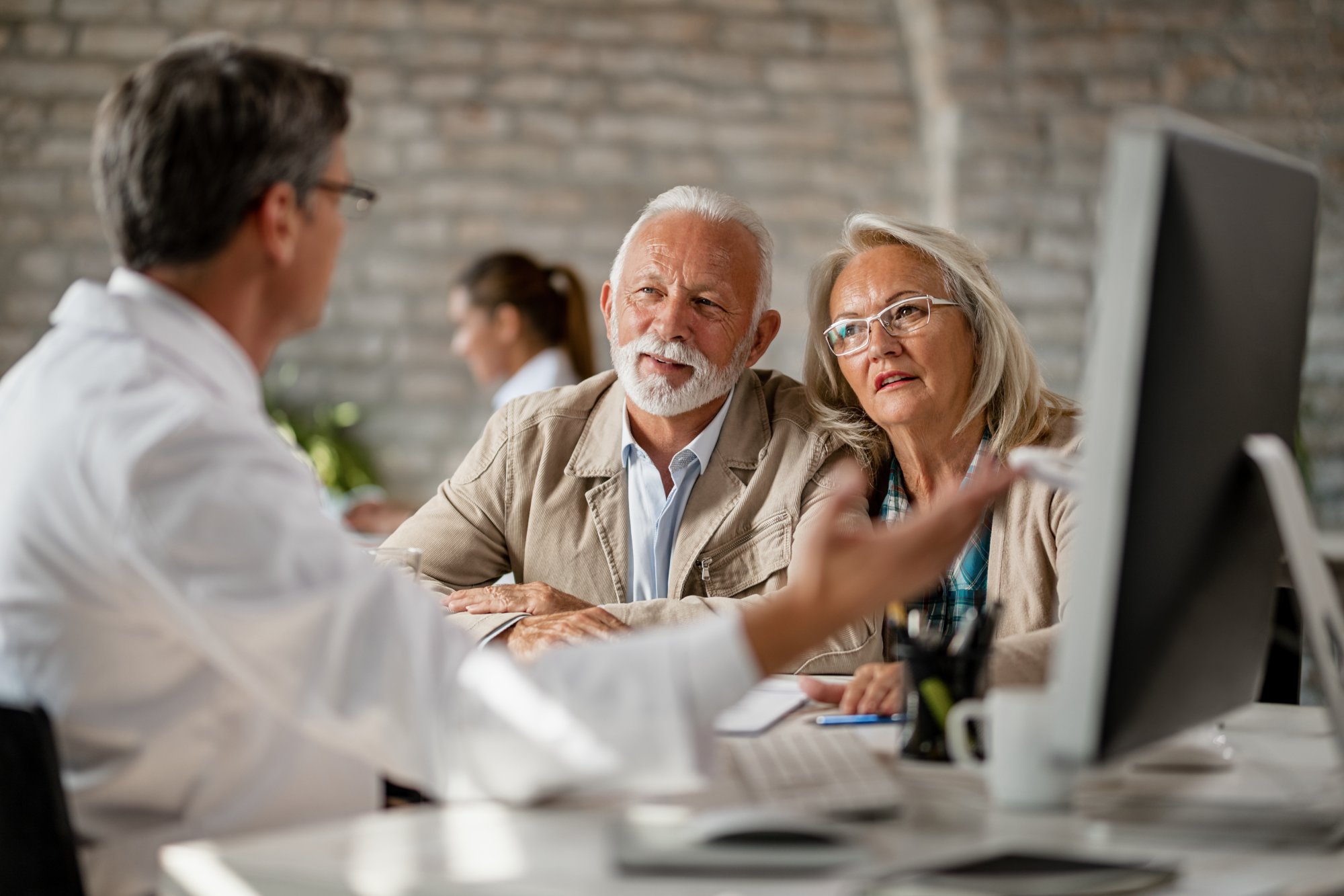 Senior couple consulting with healthcare professional about Medicare options